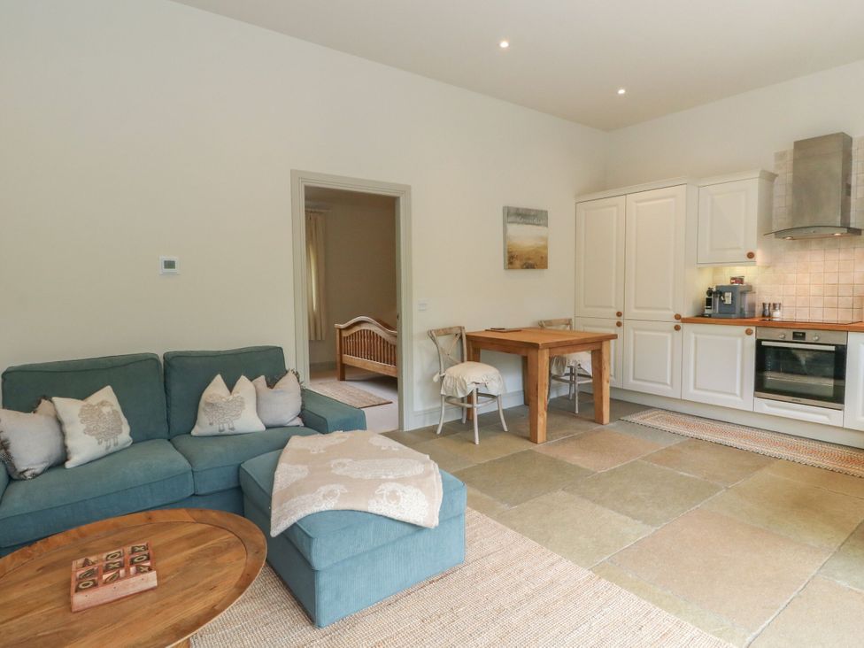 A living room with a sofa and dining table at Garth Cottage in Killin