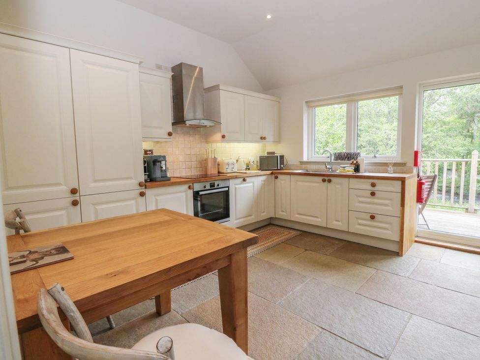 A kitchen with wooden table and cabinets at Garth Cottage in Killin