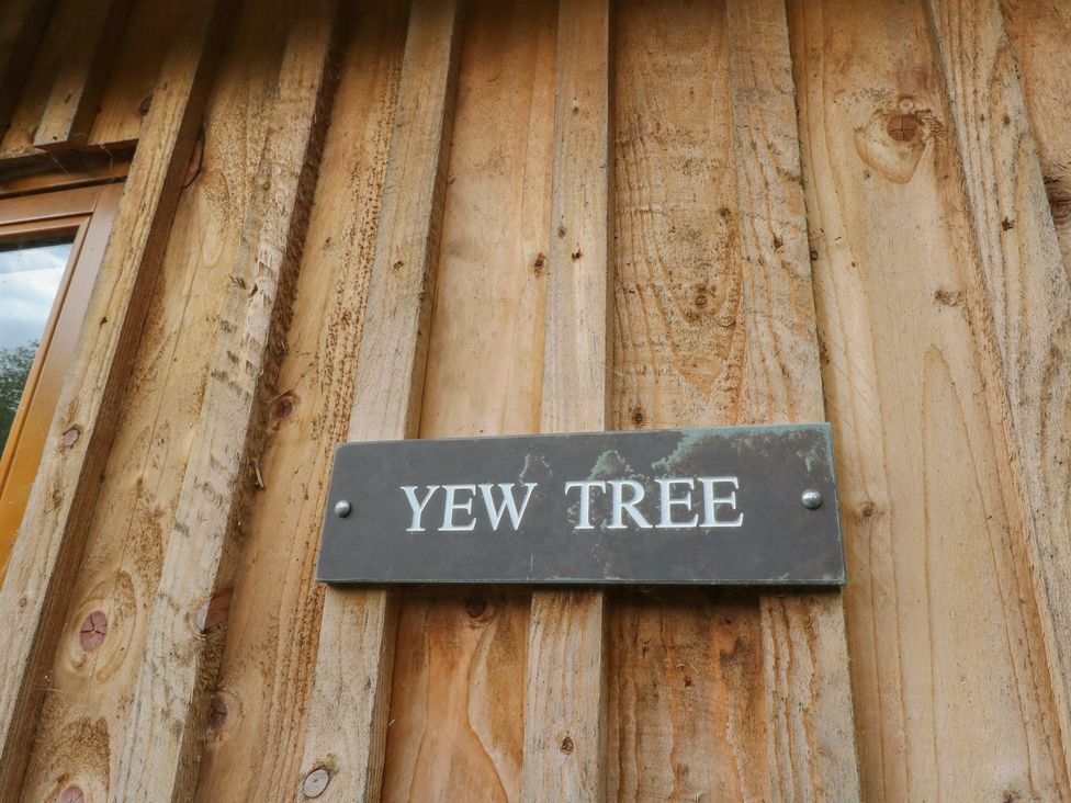 A sign displaying 'Yew Tree' on wooden exterior at Yew Tree in Killin