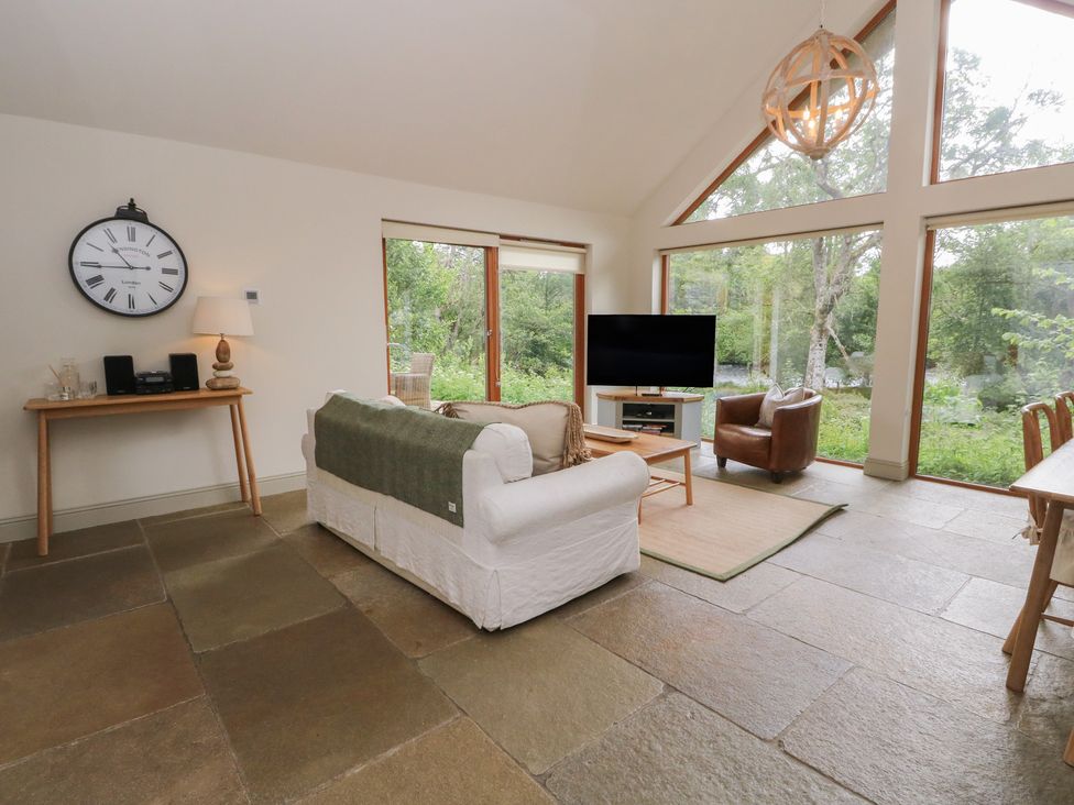 A living room with a clock and a television at Yew Tree in Killin
