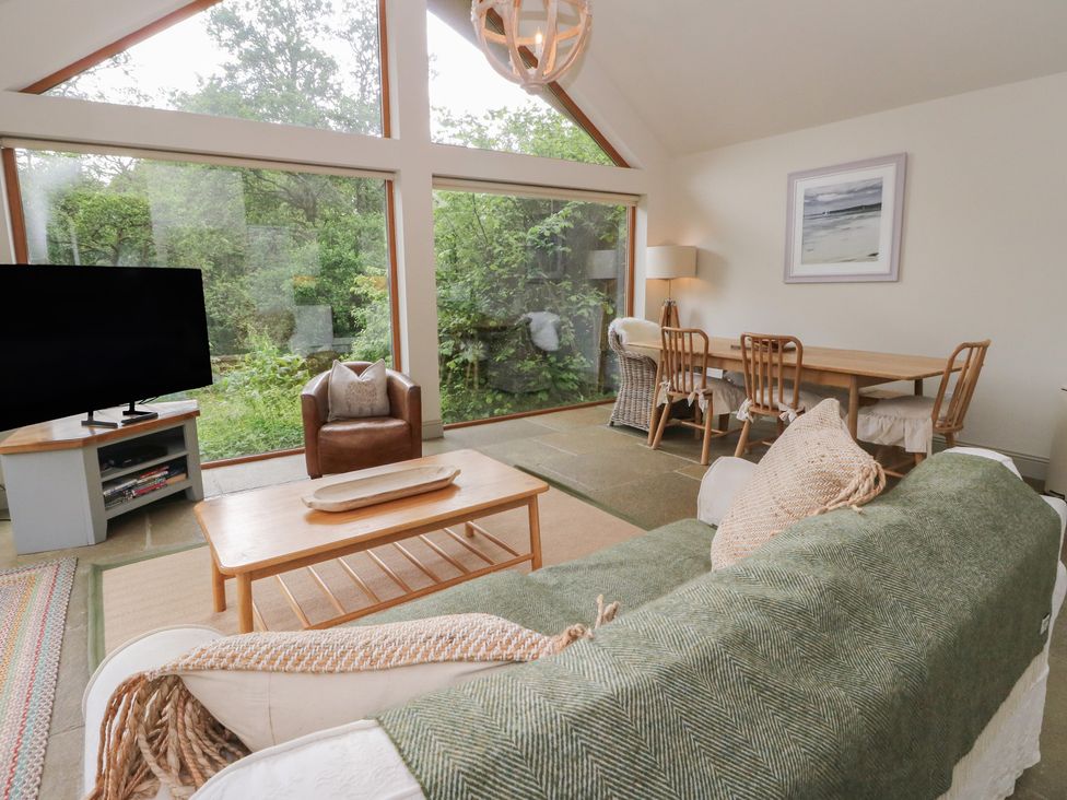 A living room with a sofa and dining area at Yew Tree in Killin