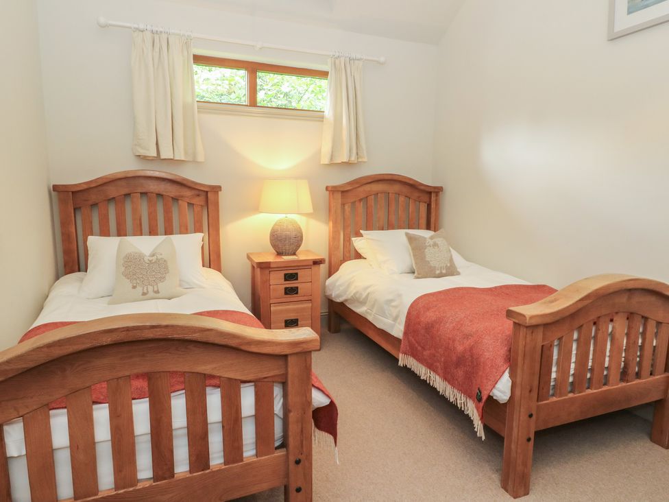 A bedroom with two beds and a lamp at Yew Tree in Killin