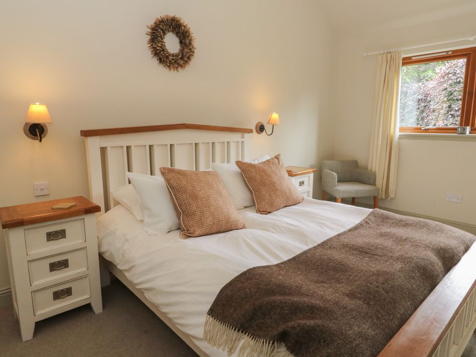 A bedroom with a bed and nightstand at Yew Tree in Killin
