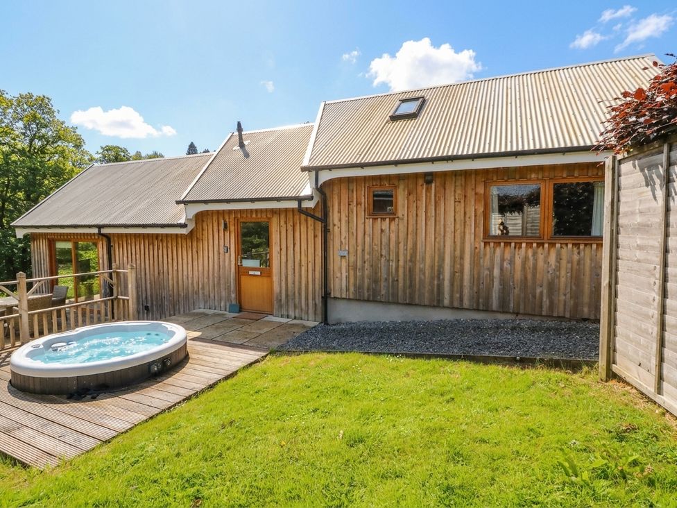 An outdoor area with a hot tub and wooden decking at Yew Tree in Killin