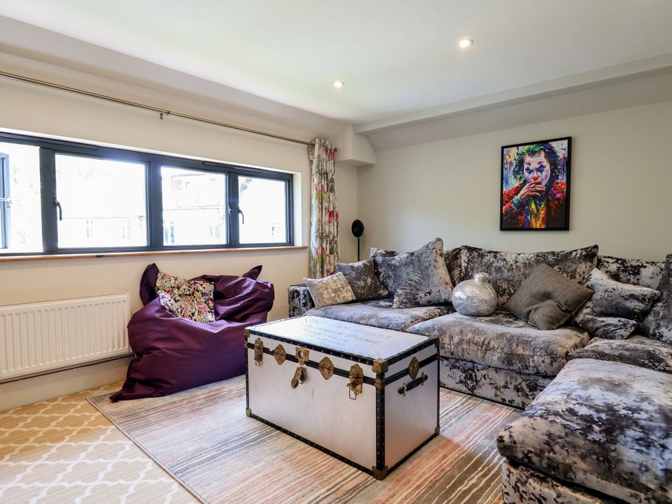 A living room featuring a sofa, bean bag, coffee table, and windows at Mayflower Cottage in Lyme Regis