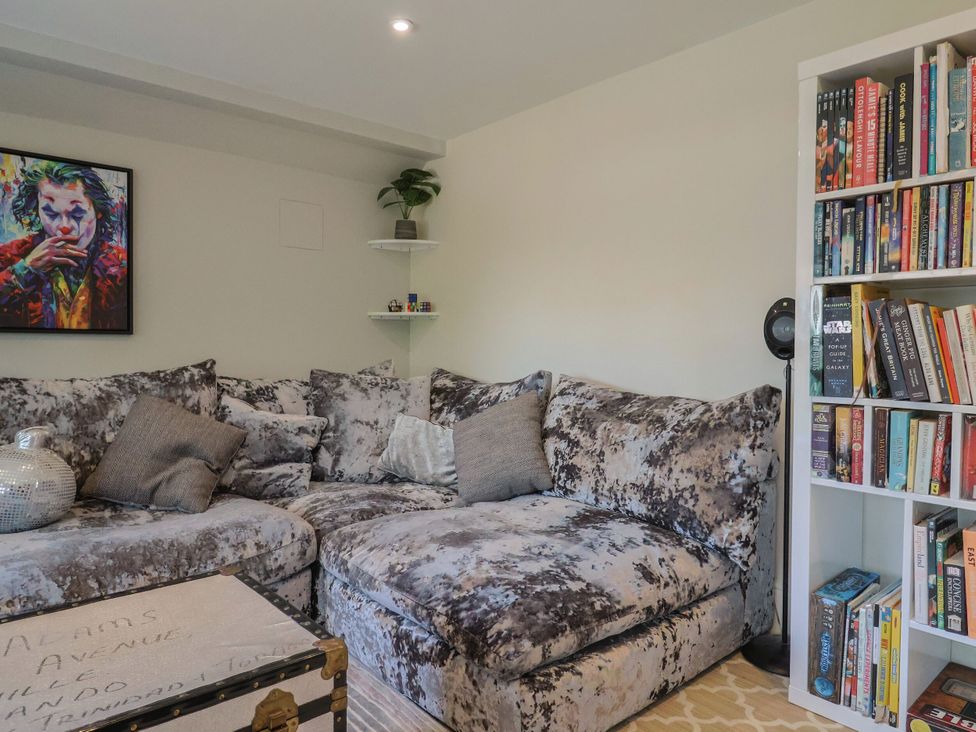 A living room with a sofa and bookshelf at Mayflower Cottage in Lyme Regis