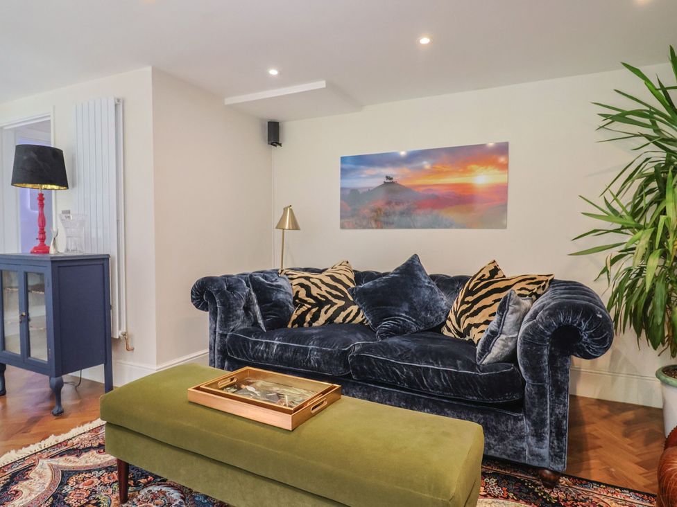 A living room with a blue sofa and a coffee table at Mayflower Cottage in Lyme Regis