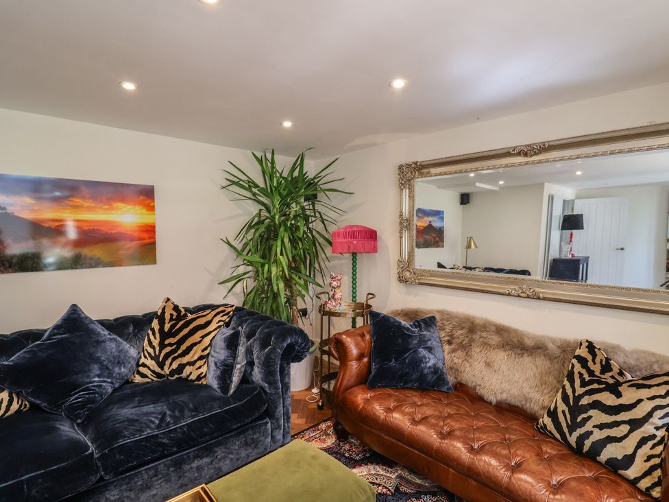 A living room with sofas and a plant at Mayflower Cottage in Lyme Regis