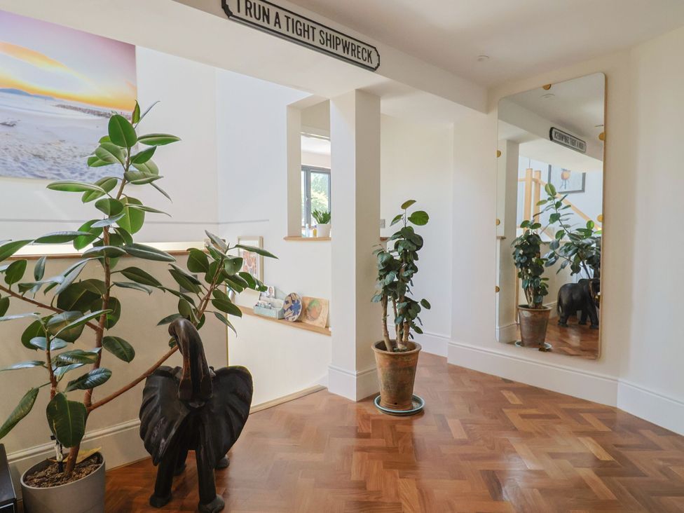 A hallway with plants and a mirror at Mayflower Cottage in Lyme Regis