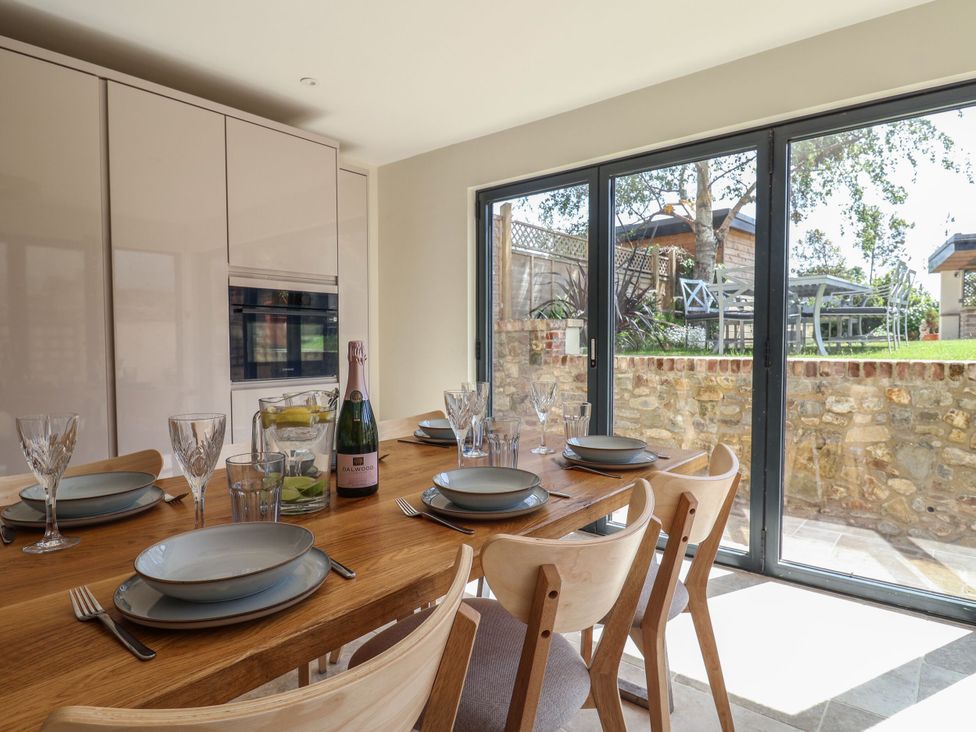A dining room with a table set for a meal at Mayflower Cottage in Lyme Regis