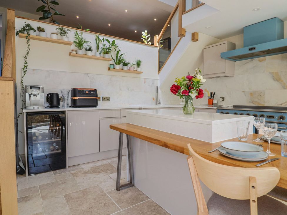 A kitchen with a cooking area and dining space at Mayflower Cottage in Lyme Regis