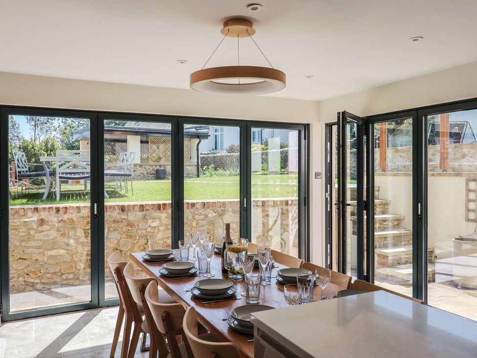 A dining room with a table set for meals at Mayflower Cottage in Lyme Regis