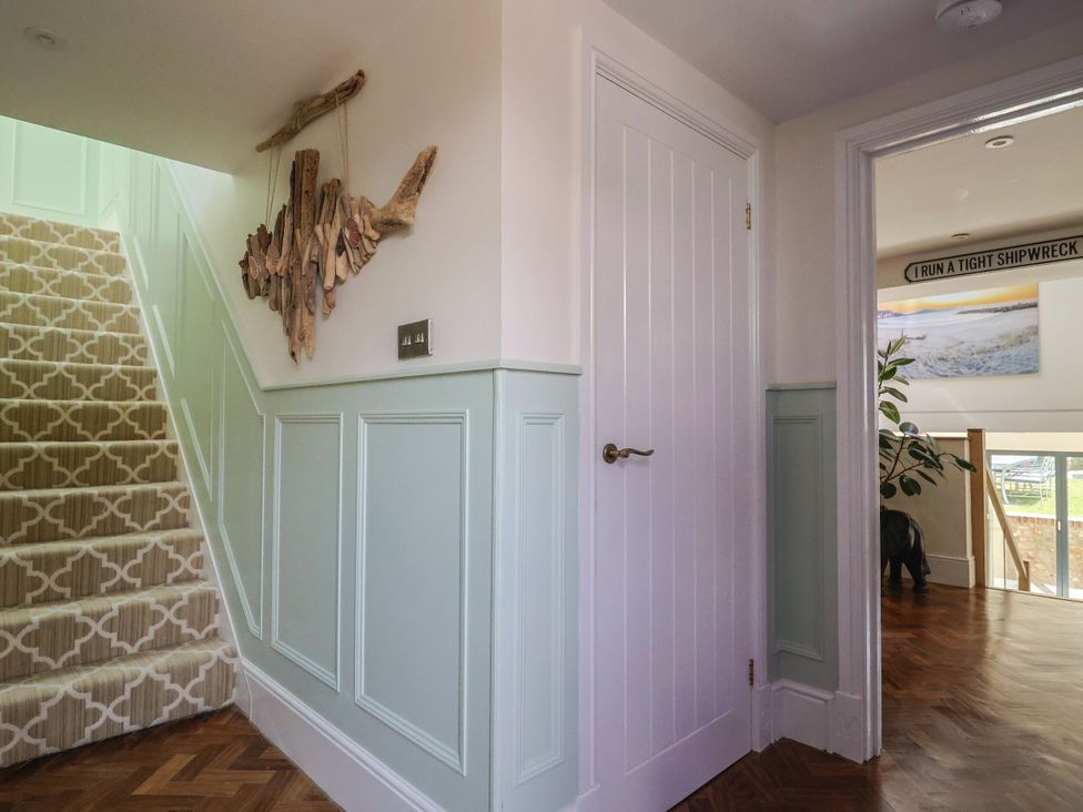 A hallway with stairs and a door at Mayflower Cottage in Lyme Regis