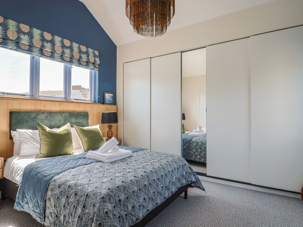 A bedroom with a bed and nightstand at Mayflower Cottage in Lyme Regis