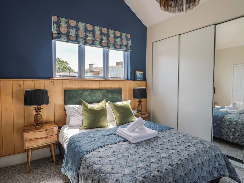 A bedroom with a bed and window at Mayflower Cottage in Lyme Regis