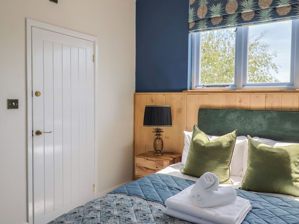 A bedroom with a bed and lamp at Mayflower Cottage in Lyme Regis