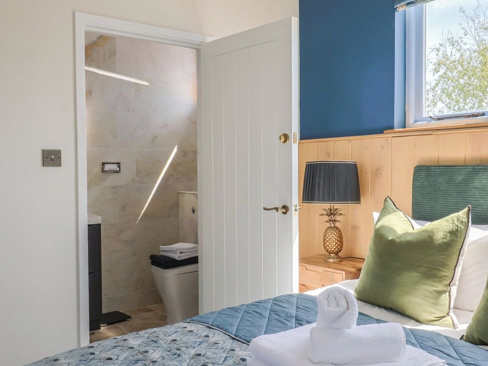 A bedroom with a view into the bathroom at Mayflower Cottage in Lyme Regis