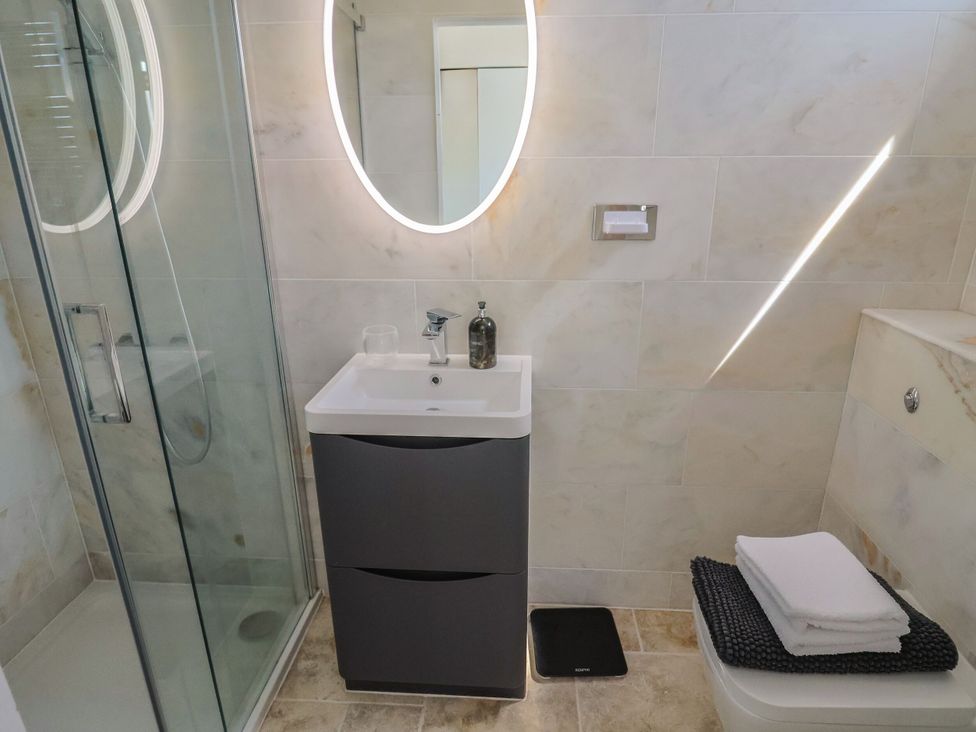 A bathroom featuring a shower, wash basin, and toilet at Mayflower Cottage in Lyme Regis