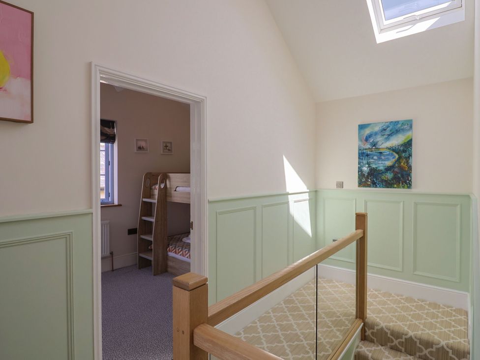 A landing with a staircase and a bunk bed at Mayflower Cottage in Lyme Regis