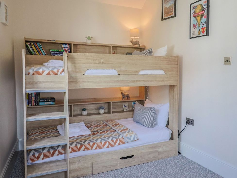 A bedroom with a bunk bed and shelves at Mayflower Cottage in Lyme Regis