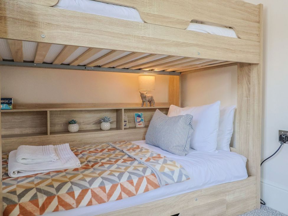 A bedroom with a bunk bed and decorative items at Mayflower Cottage in Lyme Regis