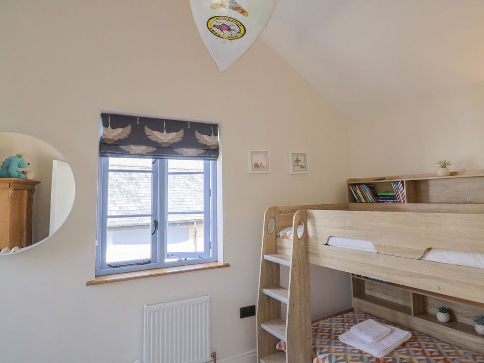 A bedroom with a bunk bed and shelves at Mayflower Cottage in Lyme Regis