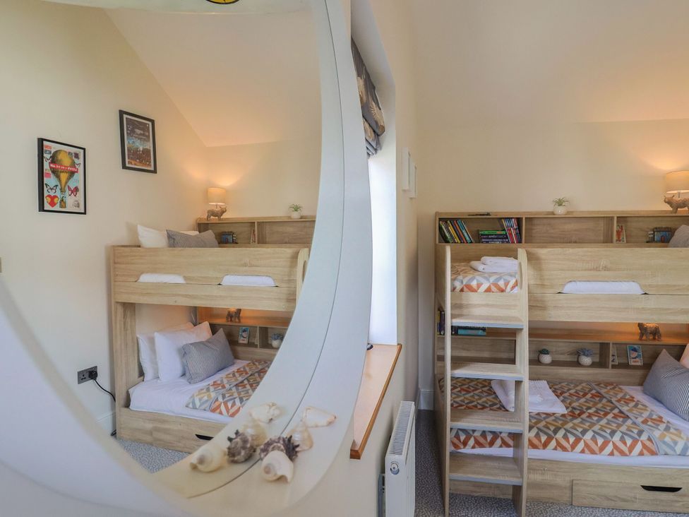 A bedroom with a bunk bed and shelves at Mayflower Cottage in Lyme Regis