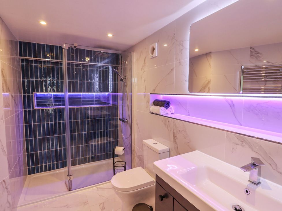 A bathroom featuring a shower, toilet, and sink at Mayflower Cottage in Lyme Regis