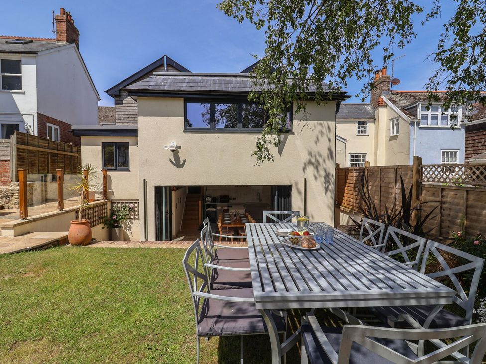 A garden with a dining table and chairs at Mayflower Cottage in Lyme Regis