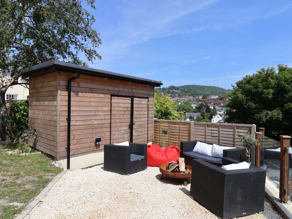 A garden with a wooden shed and outdoor seating at Mayflower Cottage in Lyme Regis