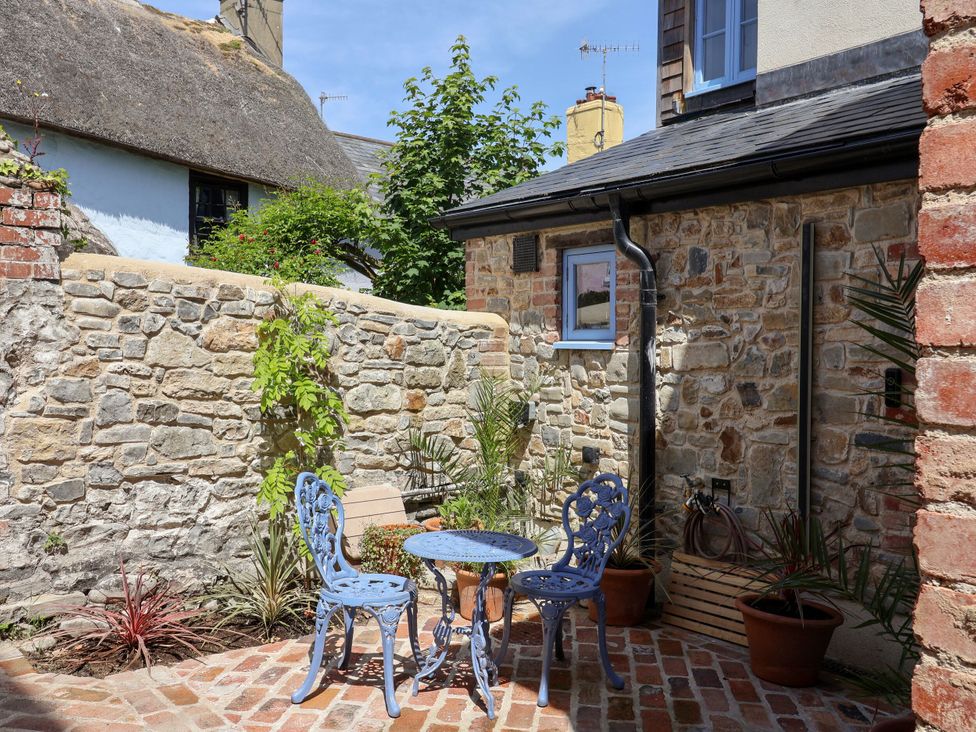 A garden with a blue table and chairs at Mayflower Cottage in Lyme Regis