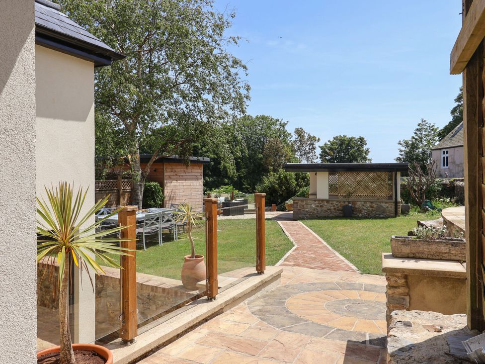 A garden area with a pathway and outdoor seating at Mayflower Cottage Lyme Regis