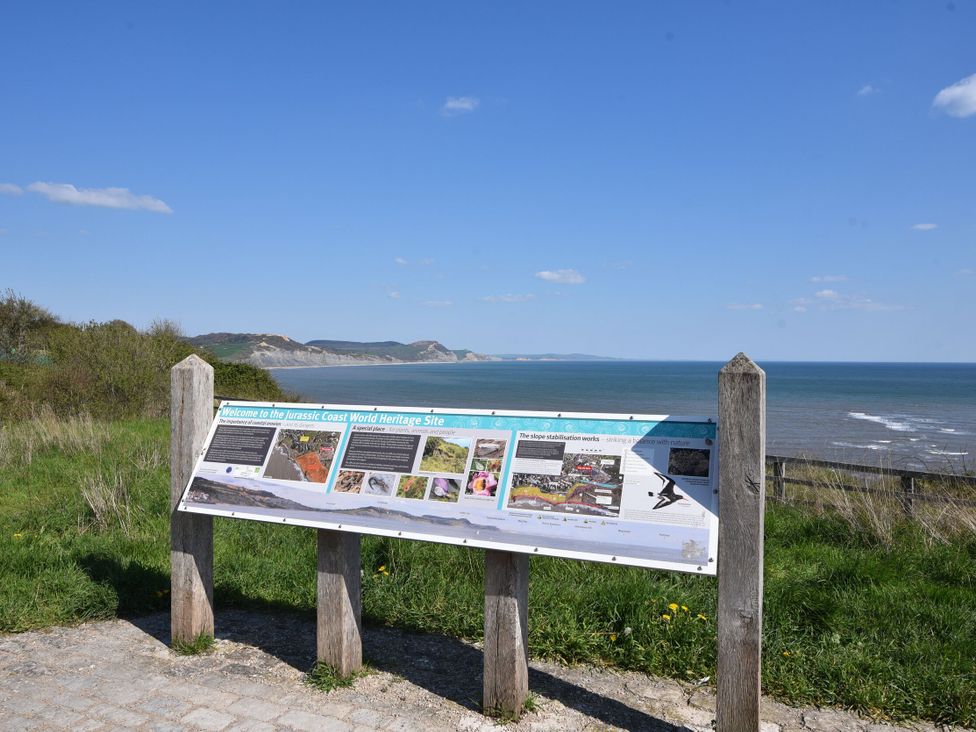 A sign detailing the Jurassic Coast World Heritage Site overlooking the ocean at Mayflower Cottage Lyme Regis