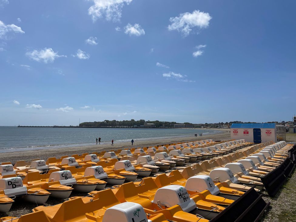 A row of pedal boats on the beach at Mayflower Cottage in Lyme Regis