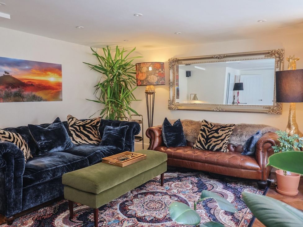 A living room with a sofa, armchair, and coffee table at Mayflower Cottage in Lyme Regis