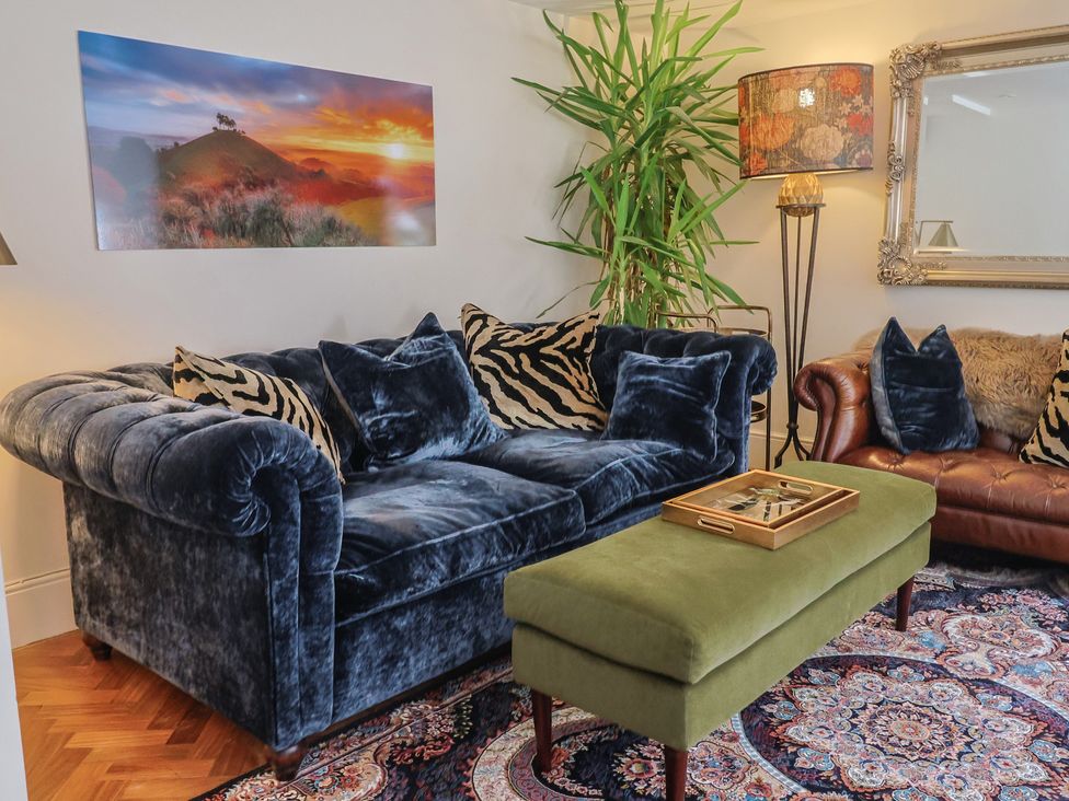A living room with sofas and a coffee table at Mayflower Cottage in Lyme Regis