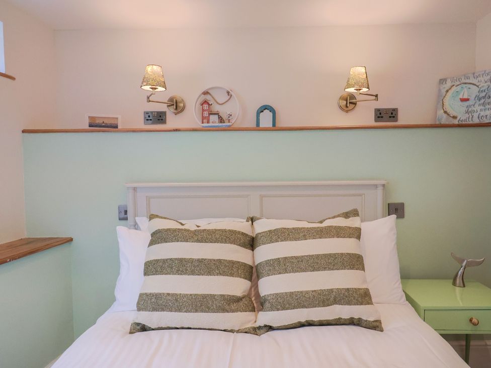 A bedroom with a bed and decorative items at Mayflower Cottage in Lyme Regis
