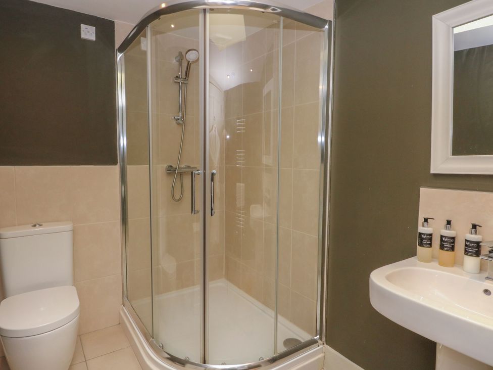 A bathroom with a shower, toilet and sink at The Crannog in Killin
