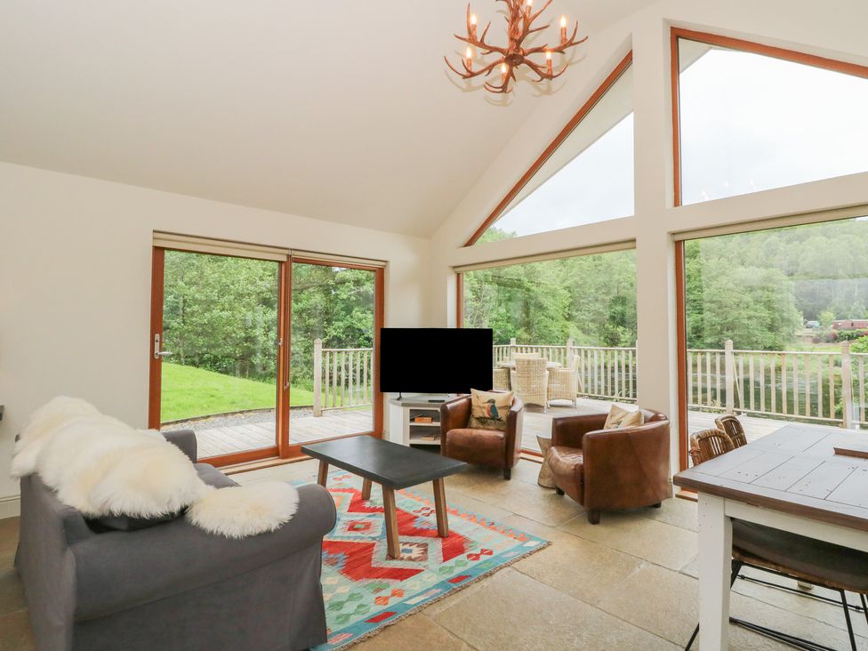 A living room with a television and seating at Riverbank Cottage in Killin