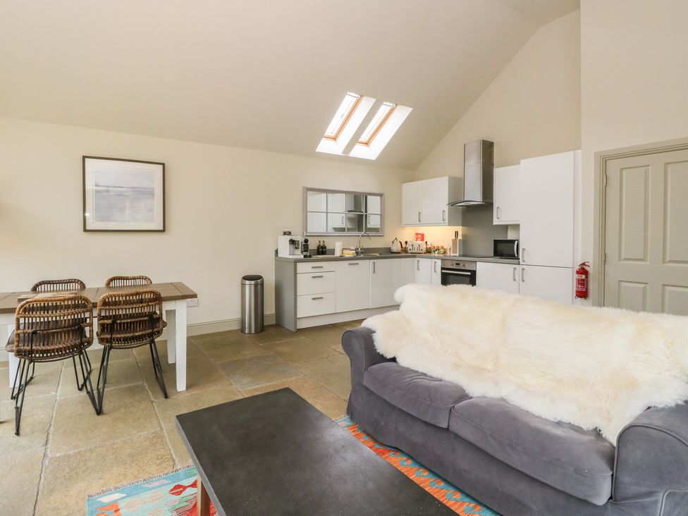 A kitchen area with sofa and dining table at Riverbank Cottage in Killin