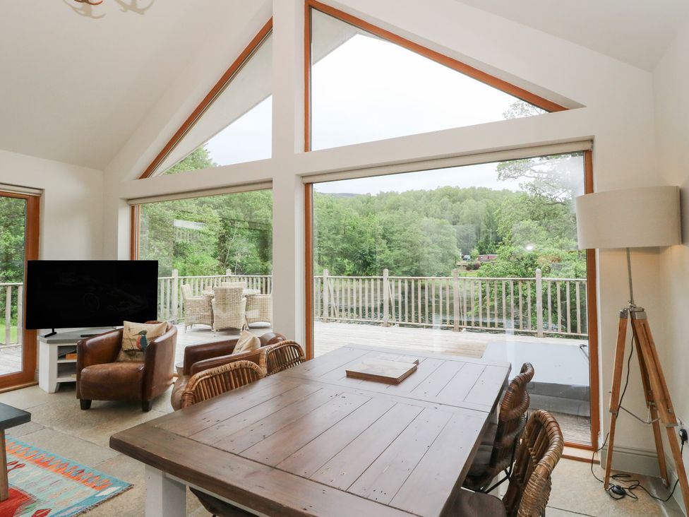 A dining room with a table and chairs at Riverbank Cottage in Killin