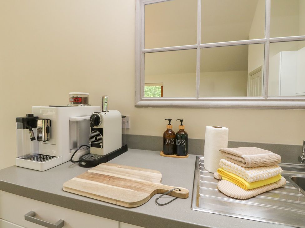 A kitchen counter with coffee machines and dish towels at Riverbank Cottage in Killin