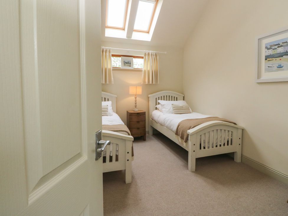 A bedroom with two beds and a lamp at Riverbank Cottage in Killin