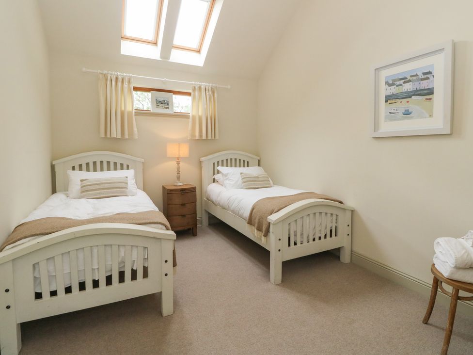 A bedroom with two beds and a lamp at Riverbank Cottage in Killin