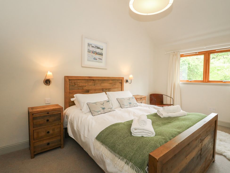 A bedroom with a bed and nightstand at Riverbank Cottage in Killin