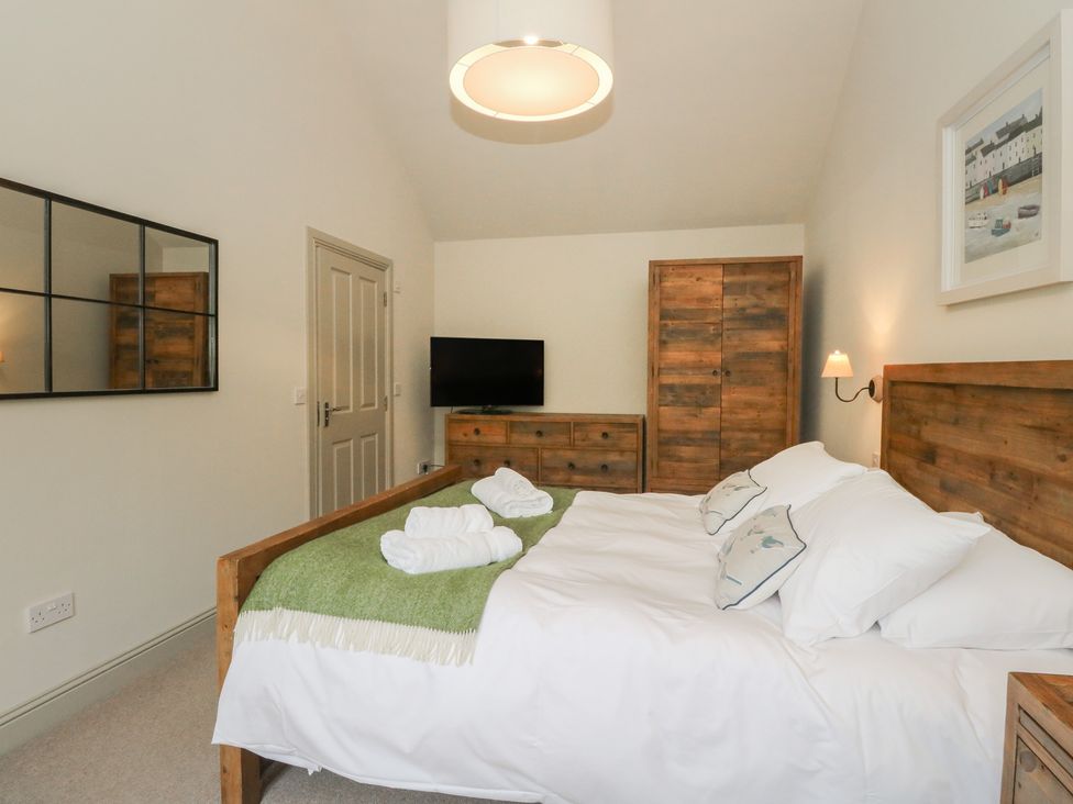 A bedroom with a bed and television at Riverbank Cottage in Killin