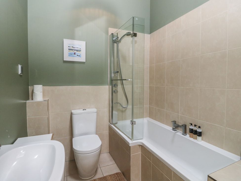A bathroom with a shower and bath tub at Riverbank Cottage in Killin