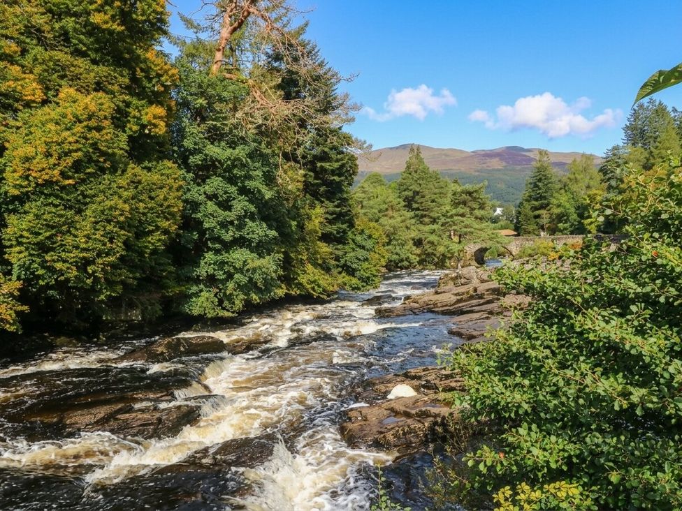 A river with rocks and trees at Riverbank Cottage in Killin