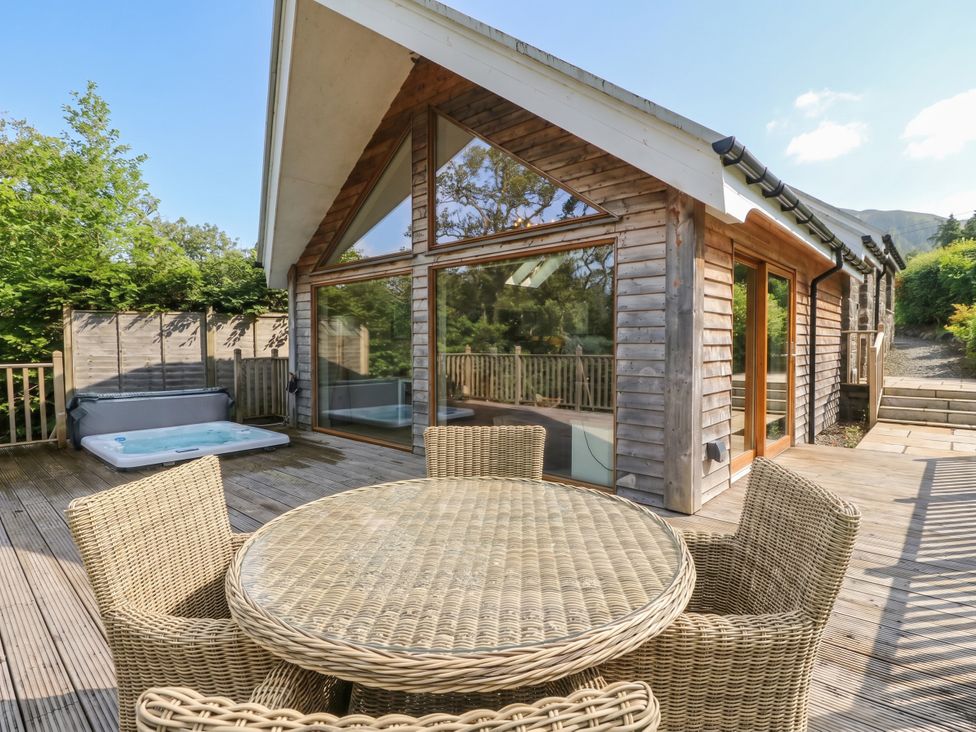 An outdoor area with a table and hot tub at Riverbank Cottage in Killin