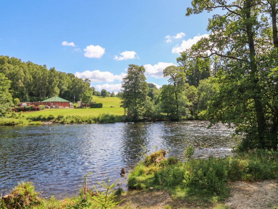 A scenic view of a river and trees at Riverbank Cottage in Killin
